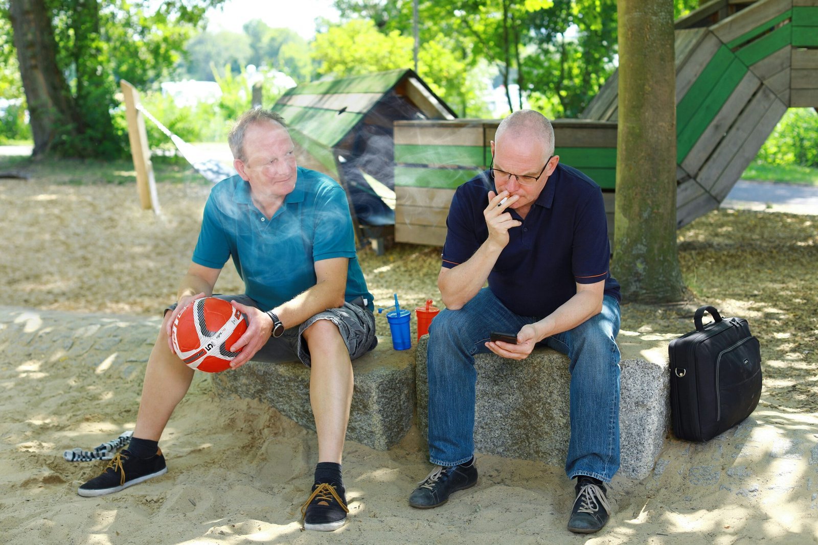 a couple of men sitting on top of a cement bench