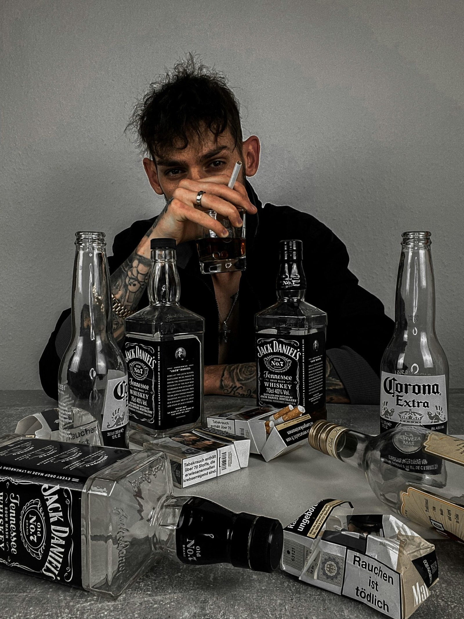 a man sitting at a table with bottles of liquor